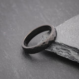 Womens black tungsten wedding band, comfort fit, photographed on a slate background