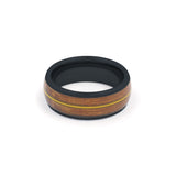 black tungsten ring featuring a recycled guitar wood and string inlay, laying flat on a white surface