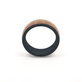 black tungsten ring featuring a recycled guitar wood and string inlay, standing upright