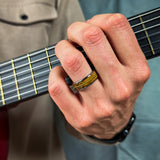 man wearing a tungsten ring with an inlay of recycled guitar wood and string