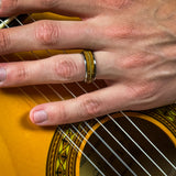 a man wearing a guitar string ring playing a guitar