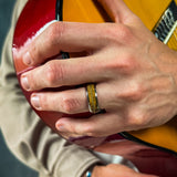 a man wearing a silver ring made from a recycled guitar