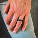 a man wearing a black hammered tungsten wedding band
