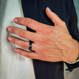 a man wearing a black hammered tungsten wedding band