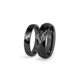 Close-up of black hammered wedding band showing textured finish