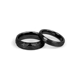 His & hers matching black wedding bands with hammered design side by side