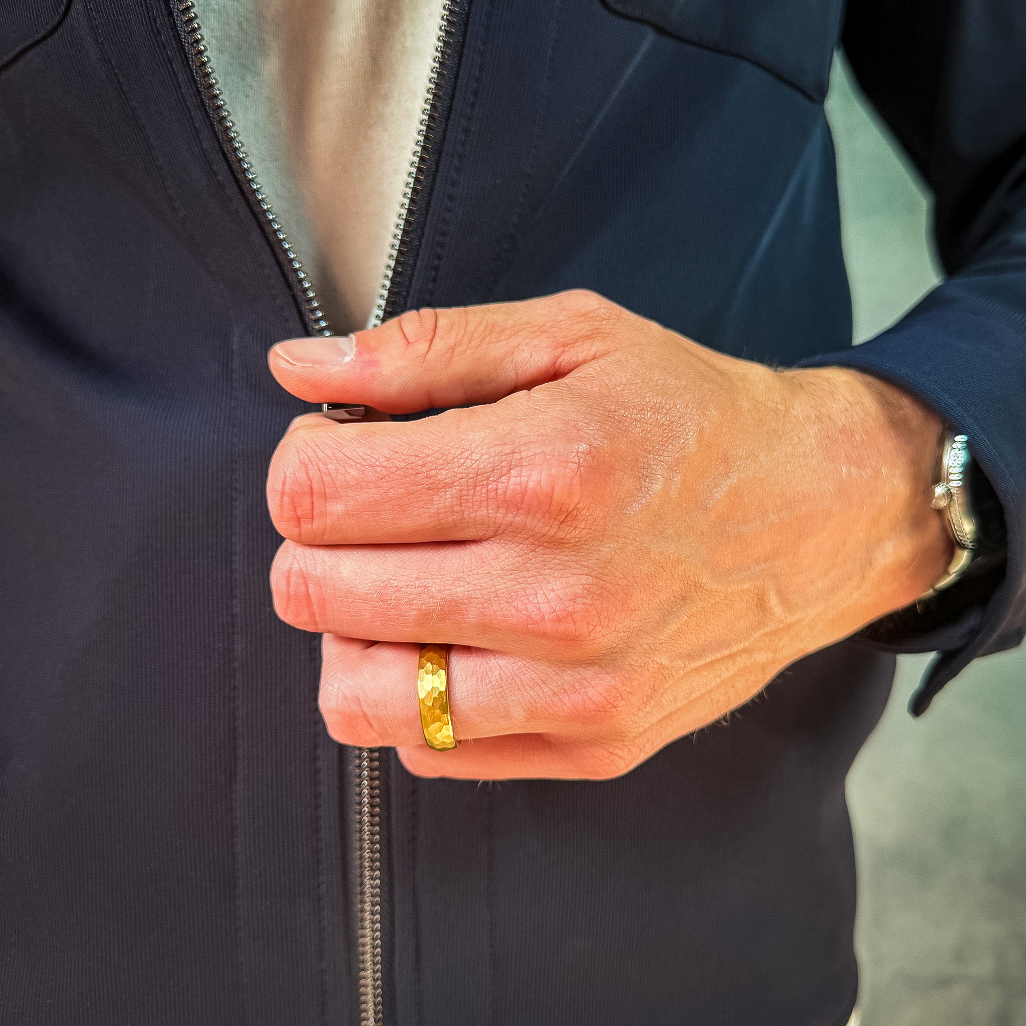 a man wearing a gold hammered tungsten wedding band