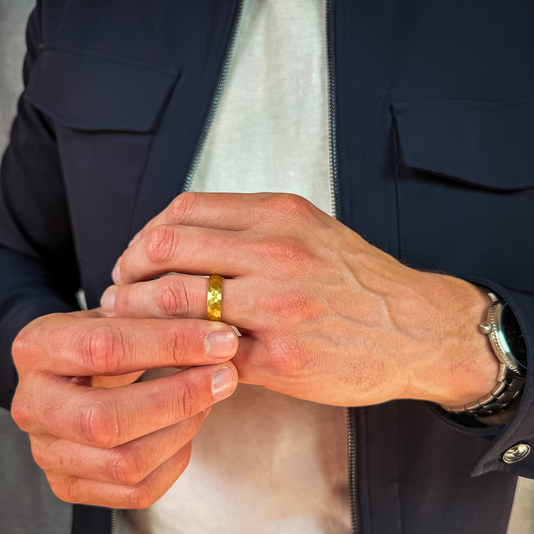 a man wearing a gold hammered tungsten wedding band