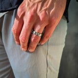 Close-up of a hand wearing a ring with a blurred background