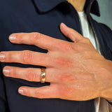 a man wearing a rose gold hammered tungsten wedding band
