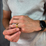 closeup of a man wearing a gold titanium wedding band