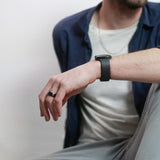 man sitting wearing a black beveled tungsten wedding ring