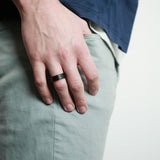 man with hand in pocket wearing a hammered tungsten wedding ring
