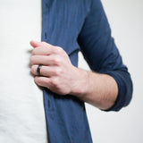 man wearing a brushed black tungsten ring with whiskey barrel wood sleeve