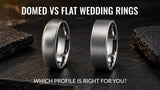 Two silver men's wedding rings with domed and flat profiles displayed side by side on a dark slate surface.