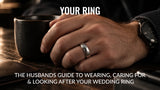 Man wearing a polished silver wedding ring with his hand resting on a dark wooden table beside a black mug.