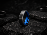 black titanium wedding band photographed on black slate