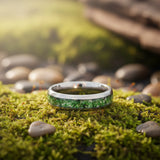 mens moss agate tungsten wedding ring photographed on a mossy surface
