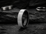 mens two tone wedding ring photographed on a reflective metal surface