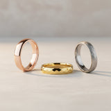 womens wedding bands photographed on a neutral stone background
