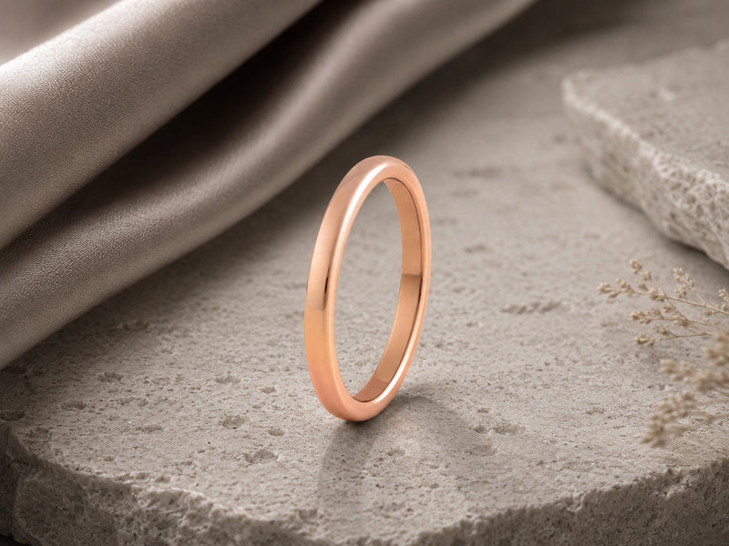 womens wedding bands photographed on a neutral stone background