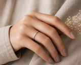 Woman wearing a slim 2mm silver tungsten wedding ring with soft neutral styling and elegant feminine luxury lighting.