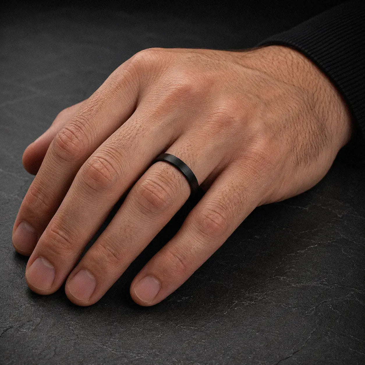 Man wearing a 4mm brushed black tungsten wedding ring with a matte brushed finish.