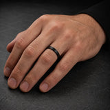 Man wearing a 4mm brushed black tungsten wedding ring with a matte brushed finish.
