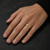 Woman wearing a 4mm brushed gold tungsten wedding ring on her left ring finger
