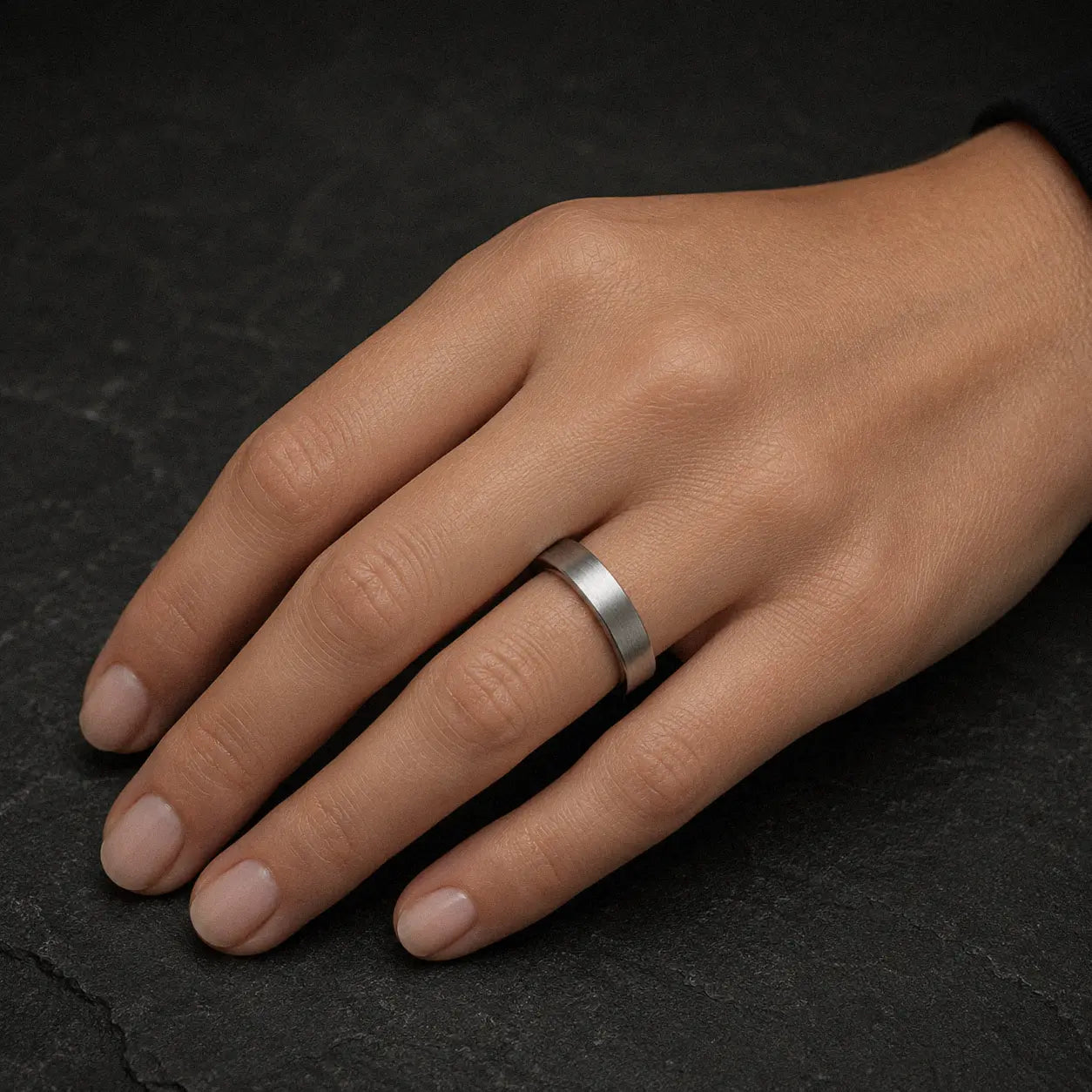 Woman wearing a 4mm brushed silver tungsten wedding ring on her left ring finger