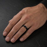 Man wearing a 6mm brushed black tungsten wedding ring with a matte brushed finish.