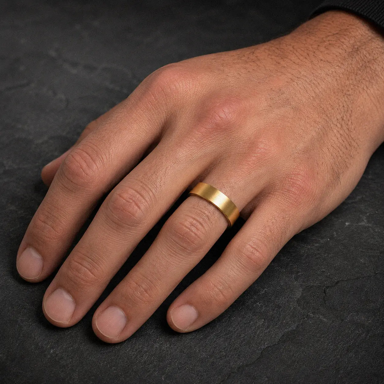 Man wearing a 6mm brushed gold tungsten wedding ring on his left ring finger