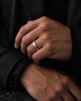 Man wearing a 6mm gold tungsten wedding ring with an imitated meteorite inlay.