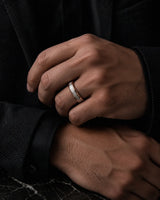 Man wearing a 6mm rose gold tungsten wedding ring with an imitated meteorite inlay.