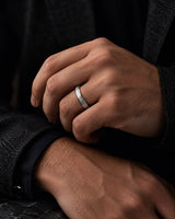 Man wearing a 6mm silver tungsten wedding ring with an imitated meteorite inlay.