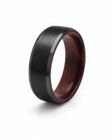Angled view of an 8mm brushed black tungsten ring with polished edges and maple wood sleeve interior