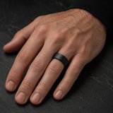 Man wearing a 8mm brushed black tungsten wedding ring on the left hand ring finger.