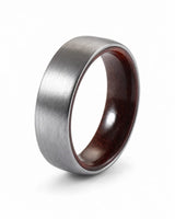 Brushed silver tungsten wedding ring with a maple wood sleeve interior shown at an angled view on a white background.