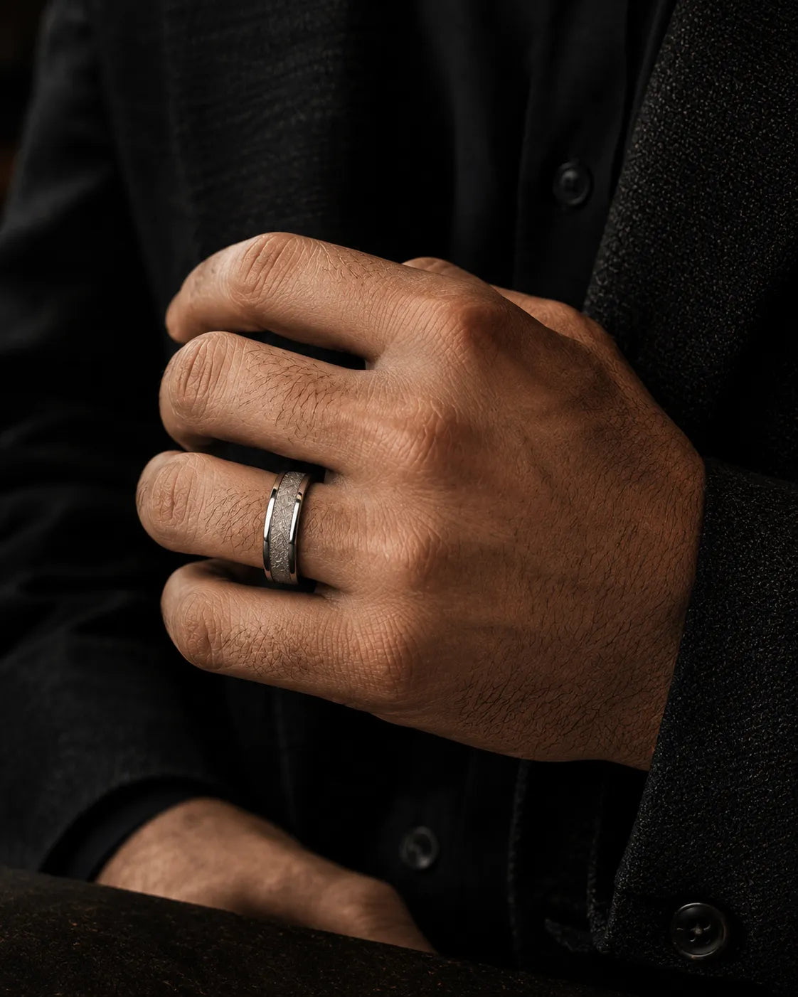 8mm silver meteorite inlay tungsten wedding ring worn by a man holding a crystal whiskey glass