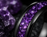 Ultra close-up macro photograph showing the detailed purple amethyst gemstone inlay and polished black tungsten edges of a luxury wedding ring.
