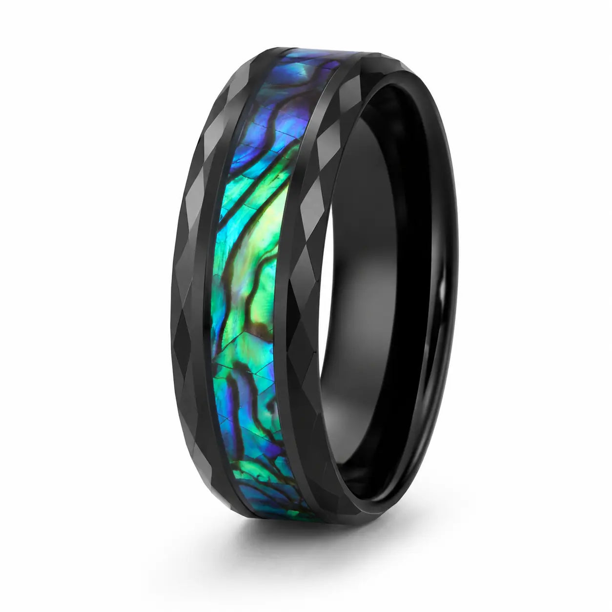 Angled view of a faceted black tungsten wedding ring with a genuine abalone shell inlay on a white background.