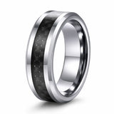 Angled view of a silver tungsten wedding ring with a black carbon fibre inlay on a white background.