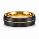 Brushed black tungsten wedding ring with an asymmetric gold groove lying flat on a white background showing the polished gold interior.