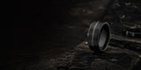 Luxury black tungsten wedding ring desktop hero banner with dark charcoal stone textures and cinematic masculine ecommerce styling.