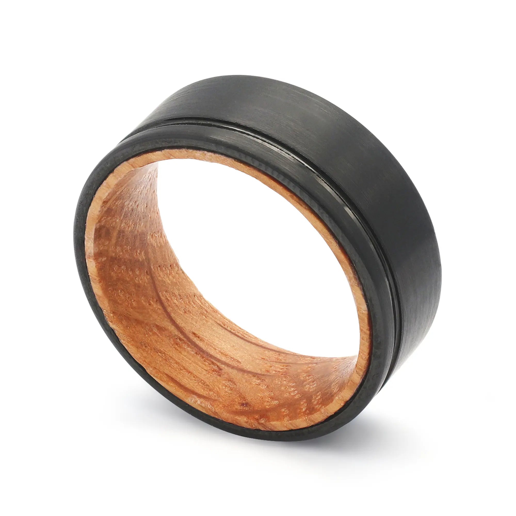 Angled view of a black groove tungsten whiskey barrel wedding ring with a real oak wood interior.