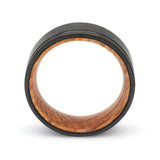 Side profile of a black groove tungsten whiskey barrel wedding ring with a reclaimed oak wood interior.