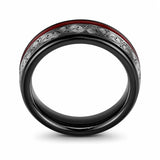 Front view of a black tungsten wedding ring with a genuine red guitar string inlay and engraved silver pattern on a white background.