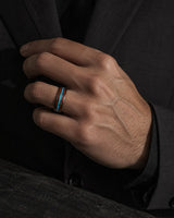 man wearing a Koa wood and abalone shell tungsten ring with polished black finish