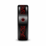 Side profile of a black tungsten wedding ring with a brushed finish, red Celtic dragon inlay and red gemstone on a white studio background.