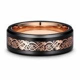Black tungsten wedding ring with a rose gold Celtic inlay lying flat on a white studio background, showing the full width of the band and polished rose gold interior.